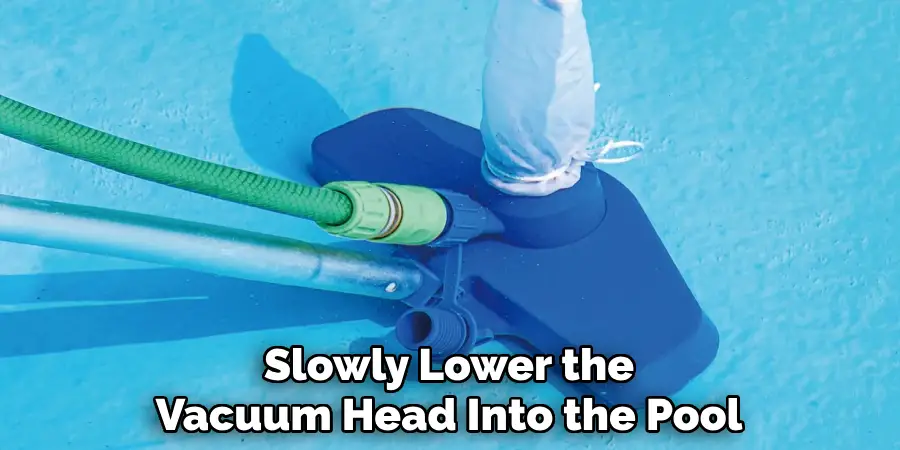 Slowly Lower the
Vacuum Head Into the Pool